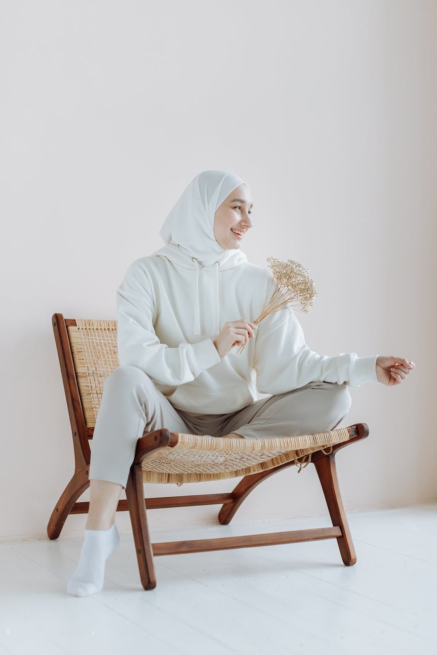 woman in white hijab sitting on brown wooden chair